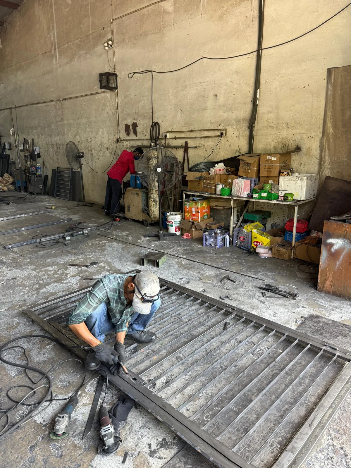 A Kam Fooi craftsman working on a steel grille in our workshop